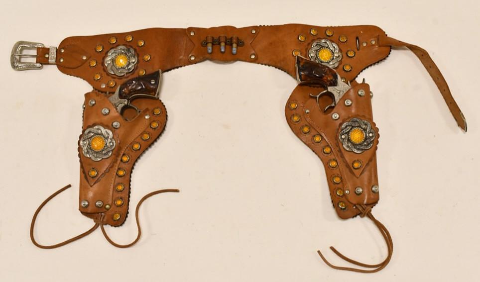 Leslie-Henry Smoky Joe Cap Gun Set w/ Holster: Leslie-Henry Smoky Joe cap gun set with leather. The cap guns have corrosion and wear from use and age. The holster has become stiff from age. Displays nicely. Each gun measures approximately 9" long.