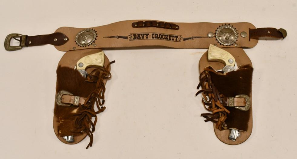 Davy Crockett Cap Gun Set w/ Davy Crockett Holster: Stevens Davy Crockett cap gun set with Davy Crockett leather holster. The one gun is missing one of the grips and does not stay latched when the trigger is pulled. The other guns trigger does not work