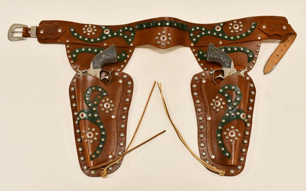 Pair Of Cap Guns w/ R.R. Rice Leather Holster: Pair of unmarked cap guns with R.R. Rice Lafayette Indiana leather holster. The cap guns have some corrosion and wear from use and age. The fancy holder displays well with some light wear considering 