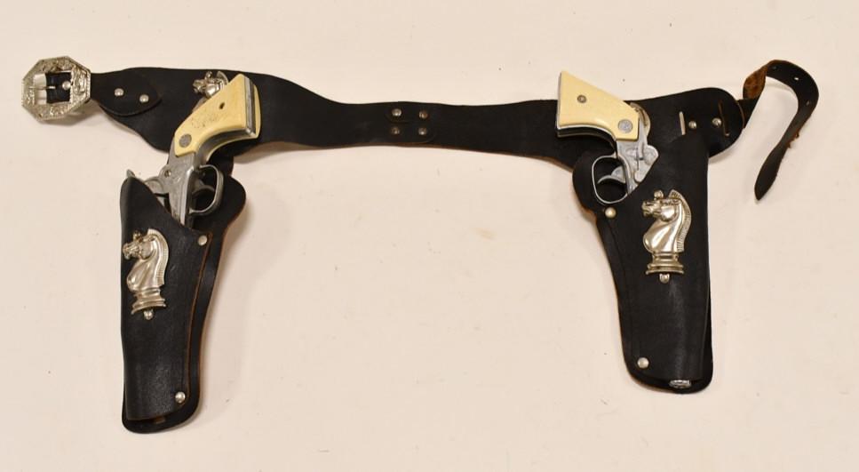 Nichols Stallion 38 Cap Gun Set w/ Leather Holster: Nichols Stallion 38 cap gun set with leather holster. The triggers work, but the cylinders only work on the one, and it doesn't spin everytime. The holder has some rusting around the metal features. E