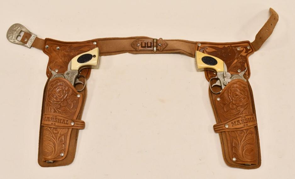Halco Marshal Cap Gun Set w/ Leather Holster: Halco Marshal cap gun set with with Marshal leather holster. The cap guns have corosion and wear from use and age. The triggers work, and the cylinders work most of the time. The holster has some crac