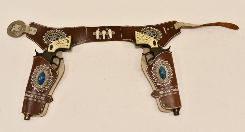 Leslie-Henry Wagon Train 44 Cap Gun Set w/ Holster: Leslie-Henry Wagon Train 44 cap gun set with Wagon Train leather holster. The cap guns have some corrosion and tarnish from use and age. The one gun works, and the other one needs some oil / fixing. E
