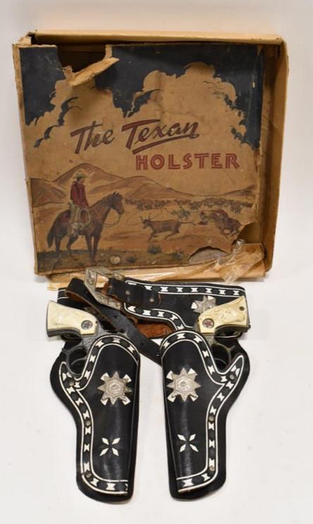 Hubley Texan Jr. Cap Gun Set w/ Holster In Box: Hubley Texan Jr. cap gun set with leather holster. Comes with the box. The box is missing some flaps and has damage. The guns have corrosion and tarnished from use and age. The triggers work. The hols
