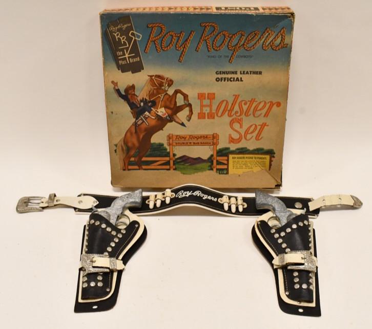 Roy Rogers Geniune Leather Official Holster Set: Roy Rogers leather holster set with (2) Roy Rogers cap guns and box. The box is missing some of the graphics on the front. The set has wear from use and age. The triggers work. Each gun measures appro