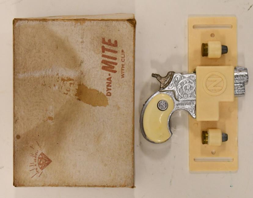 Nichols Dyna-Mite Derringer Cap Gun Pistol In Box: Nichols Dyna-Mite Derringer cap gun pistol with clip. Overall displays very well with the original box. The trigger works. The box has staining and wear from age. The gun measures approximately 3 1/4"