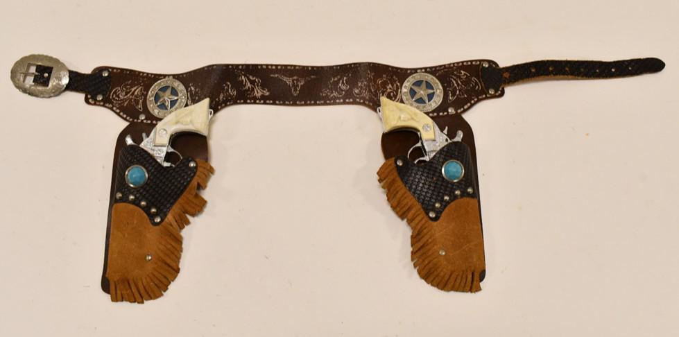 Kilgore Kit Carson Cap Gun Set w/ Leather Holster: Kilgore Kit Carson cap gun set with leather holster. The cap guns are in nice condition with minimal corrosion and wear from age. The one has a small crack in the grip. Both triggers work. The holster