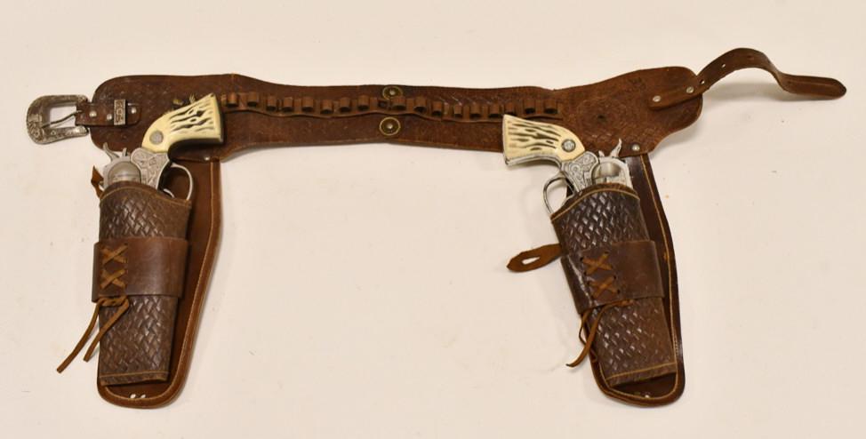 Actoy 250 Shot Cap Gun Set w/ Leather Holster: Actoy 250 Shot cap gun set with leather holster. The cap guns have some corrosion and wear from use and age. The triggers work. The holster has some cracking to the leather and the plastic bullet hold