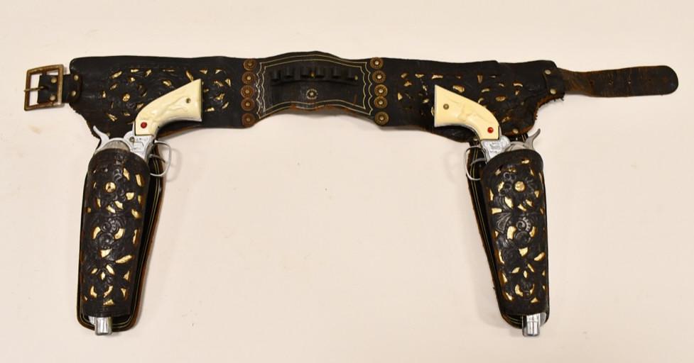Nichols Stallion 45 Cap Guns Johnny Ringo Holster: Nichols Stallion 45 cap gun set with Johnny Ringo leather holster. The leather has dried out and has wear and tear from use and age. The triggers and cylinders work on the cap guns. The cap guns have 