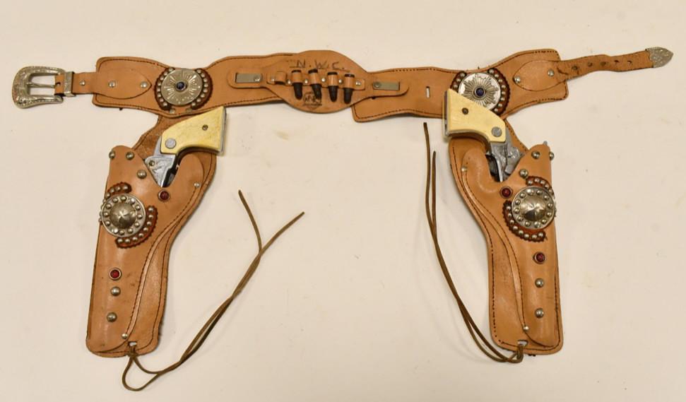 Nichols Stallion 38 Cap Gun Set w/ Leather Holster: Nichols Stallion 38 cap gun set with leather holster. The leather has dried out , has wear, and sharpie writing. The triggers work, but the cylinders do not spin. The cap guns have some corrossion and