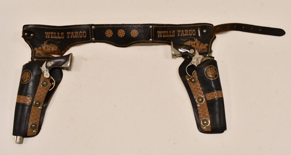 Actoy Wells Fargo Cap Gun Set w/ Leather Holster: Actoy Wells Fargo cap gun set with matching Wells Fargo leather holster. The holster is torn and is missing the buckle. The cap guns have corrosion and wear from use and age. Each gun measures approxi