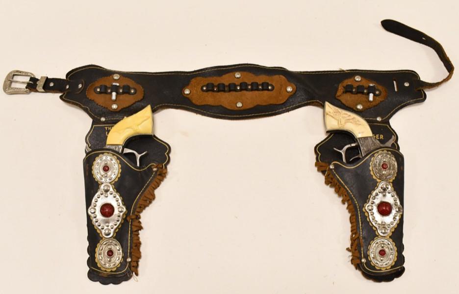 Kilgore Cast Iron American Cap Gun Set w/ Holster: Kilgore cast iron American cap gun set with Lone Ranger leather holster. The one cap gun has a broken grip and the trigger sticks. The other cap gun appears to be in working order. The holster has wea