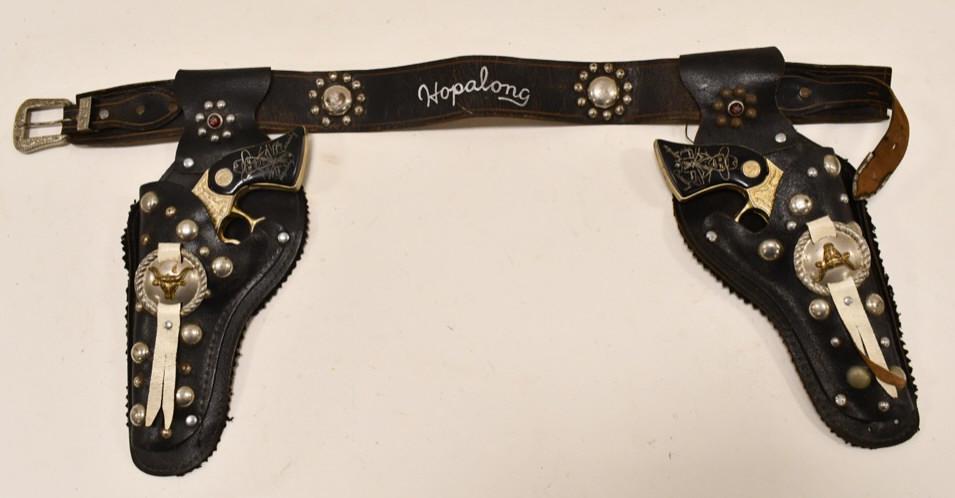 Gold Wyandotte Hopalong Cassidy Cap Gun Set: Wyandotte Toys gold Hopalong Cassidy cap gun set with matching dual leather holster. The cap guns have corrosion and wear from age. The one trigger works, but the other one does not. The holster has w