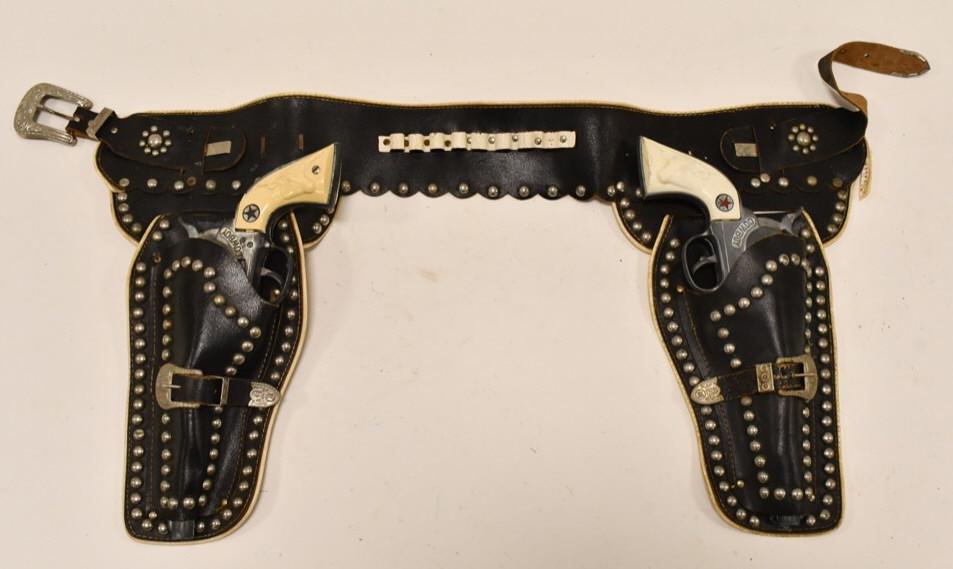 Hubley Cowboy Cap Gun Set w/ Leather Holster: Hubley Cowboy cap gun set with leather holster. The triggers work on the cap guns, but the cylinders do not. The cap guns have corrosion and wear. The leather holsters have cracking and wear. Each gun