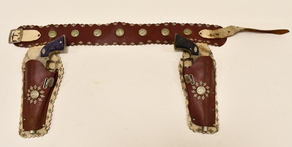 Leslie-Henry Gene Autry 44 Cap Gun Set w/ Holster: Leslie-Henry Gene Autry 44 cap gun set with leather holster. The cap guns have some tarnish and corrosion from use and age. The triggers work. The grips on the guns are not matching. The leather holst