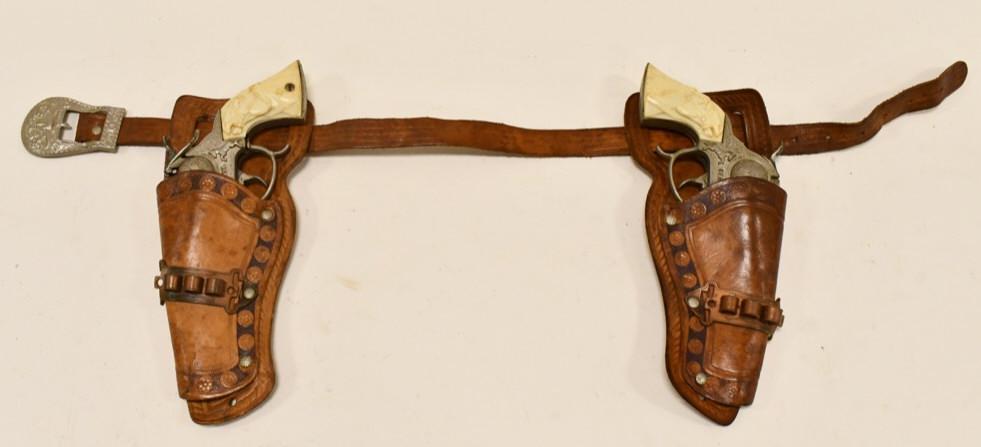 Leslie-Henry Gene Autry Cap Gun Set w/ Holster: Leslie-Henry Gene Autry cap gun set with leather holster. The cap guns have some tarnish and corrosion from use and age. The triggers work. The grips have some discoloration. The leather holster has w