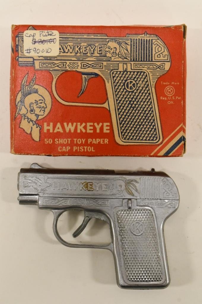 Kilgore Hawkeye 50 Shot Paper Cap Pistol w/ Box: Kilgore Hawkeye 50 shot toy paper cap pistol with the original box. The gun is in nice condition with some light corrosion and wear from age. The box has some crushing and wear from storage. Gun measu