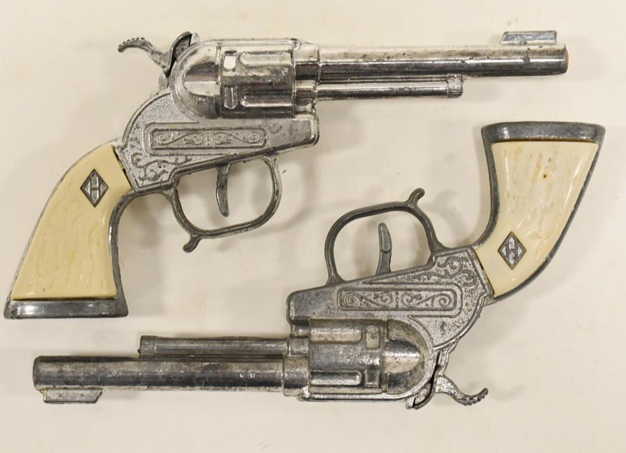 Pair of Halco Cap Gun Pistols: Pair of unmarked Halco cap gun pistols. Displays nicely with wear from play and age. Both the triggers work. Each gun measures approximately 8" long.