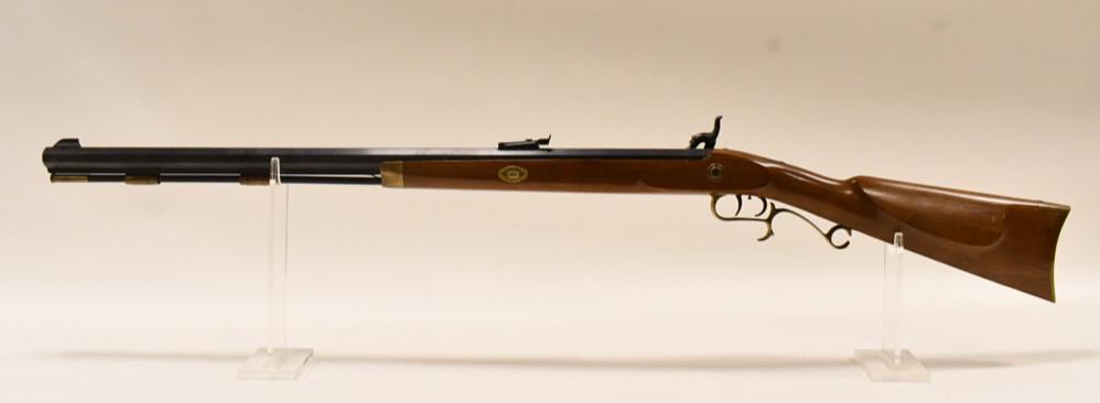 Thompson Center Arms .50 Cal. Muzzleloader: Thompson Center Arms black powder rifle in .50 caliber. The muzzleloader is in nice condition with some use wear and has a 28" barrrel and the ramrod. SN: 140951.