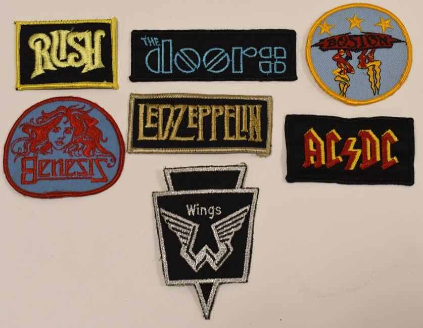 Lot Of 7 Vintage Rock And Roll Embroidered Patches: Lot of seven vintage Rock and Roll embroidered iron on patches. Lot includes Led Zeppelin, Genesis, AC/DC, Rush, Wings, The Doors, and Boston. They are all in good condition woith some wear from age a
