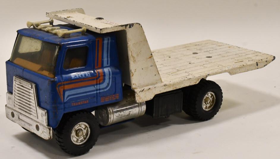 Ertl International Transtar Tilt Bed Truck: Original Ertl International Transtar tilt bed truck. The truck is missing the winch cable. The truck has paint loss and wear from play and age. Measures approximately 15" long.