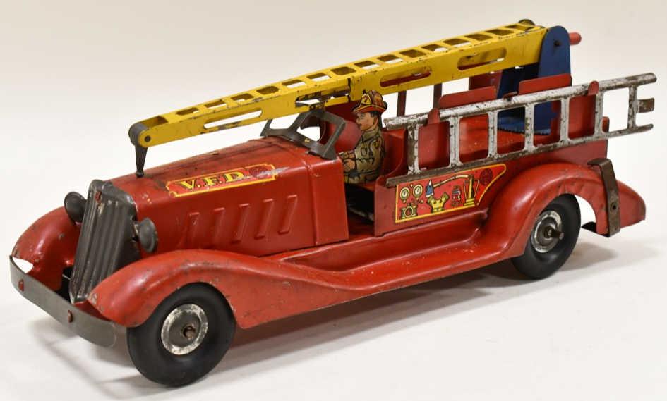 Marx Windup V.F.D. Fire Ladder Truck: Marx pressed steel V.F.D. fire aerial ladder truck. The windup works, and the crank for the aerial ladder works. The truck has paint loss and wear from play and age. Measures approximatley 14" long.