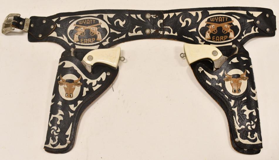 Wyatt Earp Cap Gun Set w Leather Holster: Vintage Hubley Wyatt Earp cap gun set with Wyatt Earp leather holster. The cap guns have corrosion and wear from use and age. Both triggers move the hammers. The holster has some wear and tear from ag