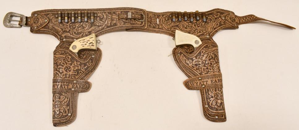 Wyatt Earp Cap Gun Set w Leather Holster: Vintage Hubley Wyatt Earp cap gun set with Wyatt Earp leather holster. The cap guns have corrosion and wear from use and age. Both triggers move the hammers. The holster has some wear and tear from ag