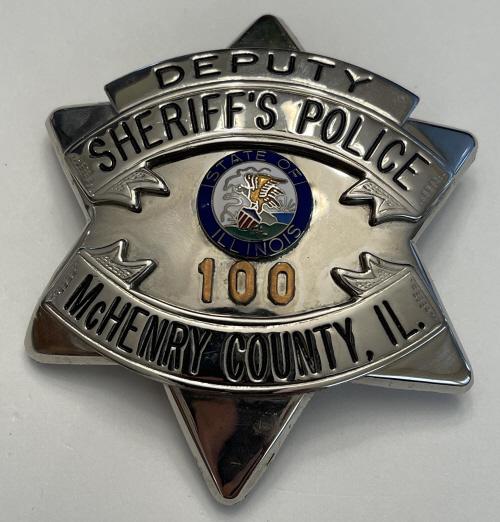 Obsolete McHenry County IL Sheriff Pie Plate Badge: Obsolete McHenry County IL Deputy Sheriff's Police Pie Plate Badge. Bade number 100. Unmarked on back of badge. Presents well but one of the points tip is slightly bent. Pinback in good condition. Mea