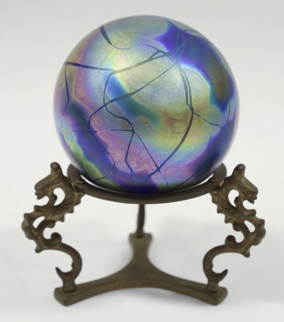 Susan Anton Carr Intaglio Art Glass Sphere W/Stand: Intaglio irridescent blue & gold art glass sphere with brass stand by Susan Anton Carr. The signed sphere measures 4" tall and with the stand measures 6" tall. It is in great condition.