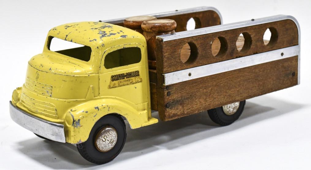 Original Smith Miller GMC Barrel Delivery Truck: Original Smith Miller GMC barrel delivery truck. Displays well with yellow GMC ca, wood and metal bed, and Smith Miller hubcaps. The truck has paint loss and wear from play and age. Measures approxima
