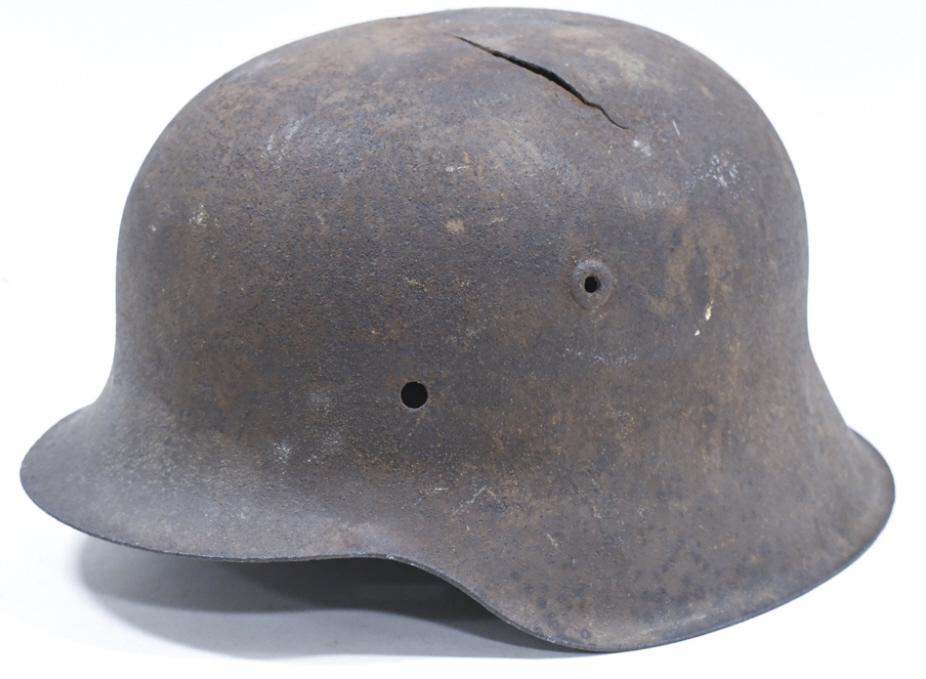 WWII German M42 Military Combat Helmet: WWII German M42 miltary combat helmet. Helmet is in worn condition with rust, damage, and wear from use and age. It is missing its liner. Still displays well with a great look.