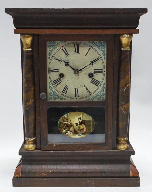 Antique Waterbury Wood Mantel Clock: Antique Waterbury Clock Co. wood mantel clock. With pendulum and key. Working condition, has surface wear and cracking. Measures 12" across, 16.5" tall, 4.5" deep.
