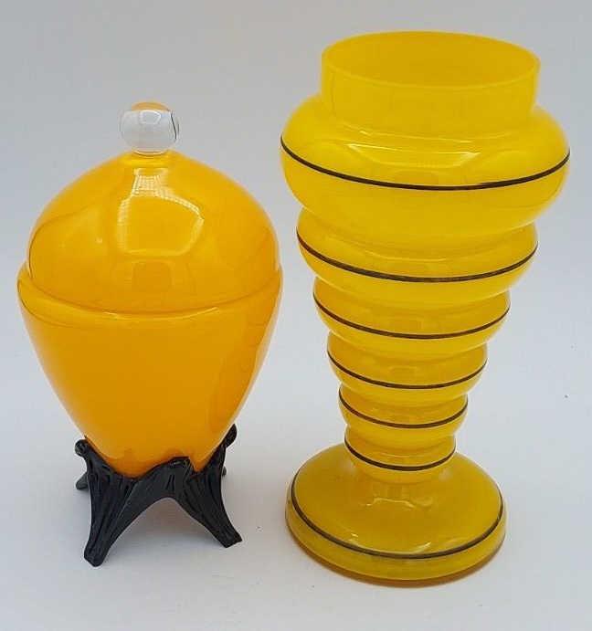 Two Czech Tango Pieces of Art Glass: Set of two Czech tango art glass pieces. One yellow and black vase, measure 4" across, 7.75" tall. One yellow and black lidded vessel, measures 3.75" across, 7" tall.