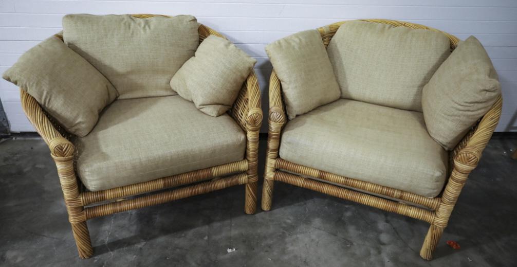 The Wicker Works Pair Of Chairs: The Wicker Company pair of sitting chairs with raw silk upholstered cushions. Good condition with some wear from use. Each Measues 30" across, 32" deep, 31" tall.