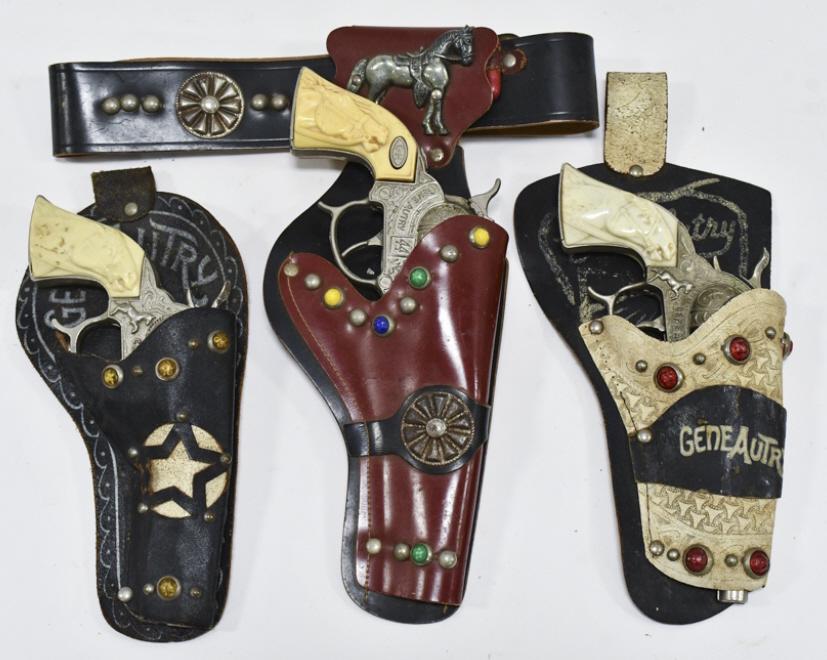 Lot Of Gene Autry Holsters & Cap Guns: Lot includes three single holsters, and two of them are marked Gene Autry. It comes with a Leslie-Henry Gene Autry 44 cap gun, Leslie-Henry Gene Autry cap gun, and Leslie-Henry Gene Autry "Champion" c