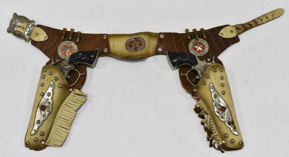 Leslie Henry Gene Autry Cap Gun Set w/ Holster: Leslie Henry Gene Autry cap gun set with leather holster. The guns have some corrosion and wear from use and age. Each gun measures approximately 9" long.