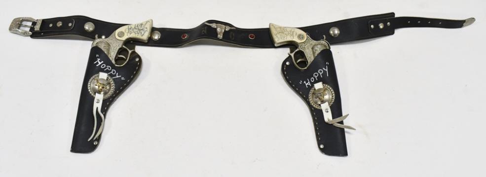 Wyandotte Hopalong Cassidy Cap Gun Set w/ Holster: Wyandotte Toys Hopalong Cassidy cap gun set with Hopalong Cassidy leather holster. The cap guns have some corrosion and wear from use and age. The holster has some cracking and wear from age. Each gun
