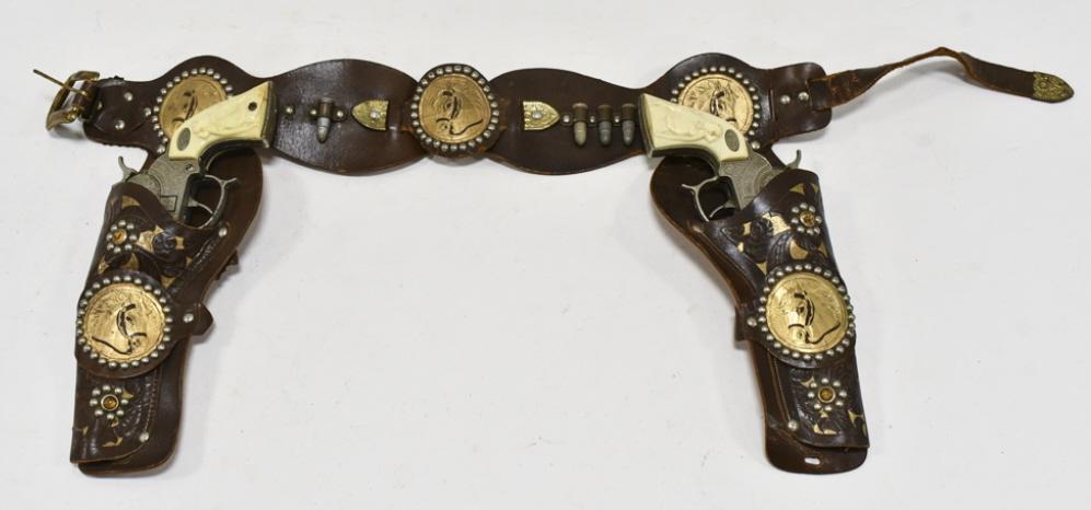 Leslie Henry Gene Autry 44 Cap Gun Set w/ Holster: Leslie Henry Gene Autry 44 cap gun set with leather holster. Some of the grips have cracks. The cap guns have some corrosion and wear from use and age. The holster has some cracking and wear from age.