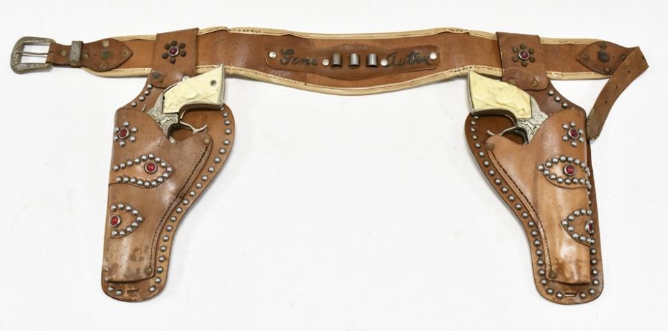 Leslie Henry Gene Autry Cap Gun Set w/ Holster: Leslie Henry Gene Autry cap gun set with Gene Autry leather holster. The cap guns have corrosion and wear from use and age. The holster has some cracking and wear from age. Each gun measures approxima