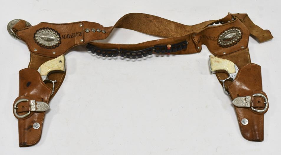 Leslie Henry Maverick Cap Gun Set w/ Holster: Leslie Henry Maverick cap gun set with Maverick leather holster. The cap guns have some corrosion and wear from use and age. One of the grips is cracked. The holster has some cracking and wear from ag