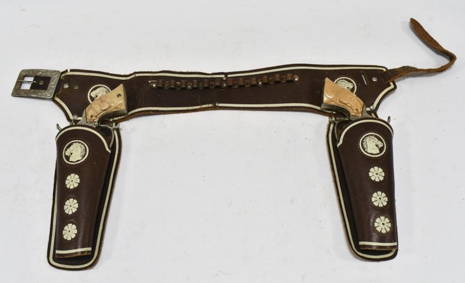 Leslie Henry Smoky Joe Cap Gun Set w/ Holster: Leslie Henry Smoky Joe cap gun set with Johnny Ringo leather holster. The cap guns have some corrosion and wear from use and age. The holster has some cracking and wear from age. Each gun measures app