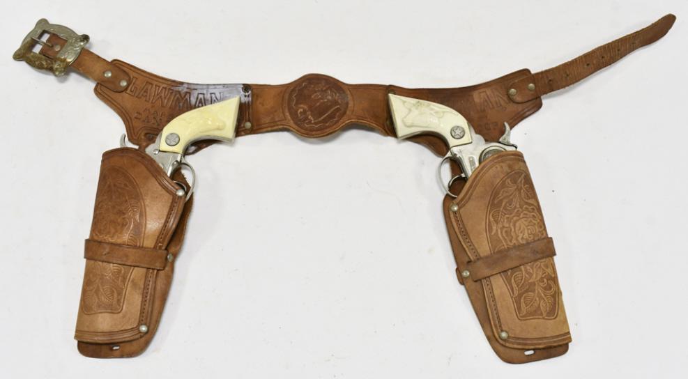 Hubley Marshal Cap Gun Set w/ Leather Holster: Hubley Marshal cap gun set with Lawman leather holster. The cap guns have some corrosion and wear from use and age. The holster has some cracking and wear from age. Each gun measures approximately 9-1