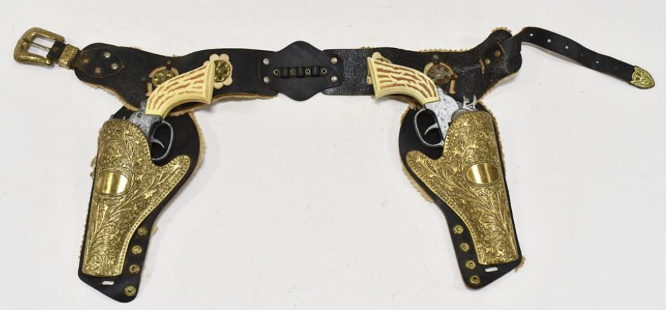 American West Frontier 45 Cap Gun Set w/ Holster: American West Frontier 45 cap gun set with leather holster. The cap guns have some corrosion and wear from use and age. The holster has some cracking and wear from age. Each gun measures approximately