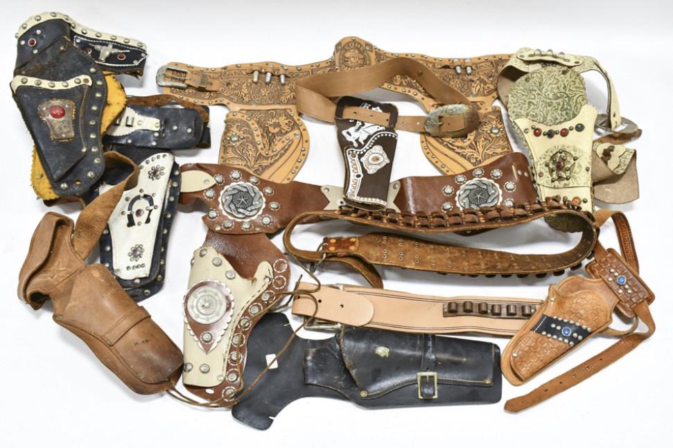 Lot Of Vintage Leather Cap Gun Holsters: Lot of vintage leather cap gun holsters. Includes belts, some single holsters, and some dual holsters. Some with belts and some without. All have wear from use and age.