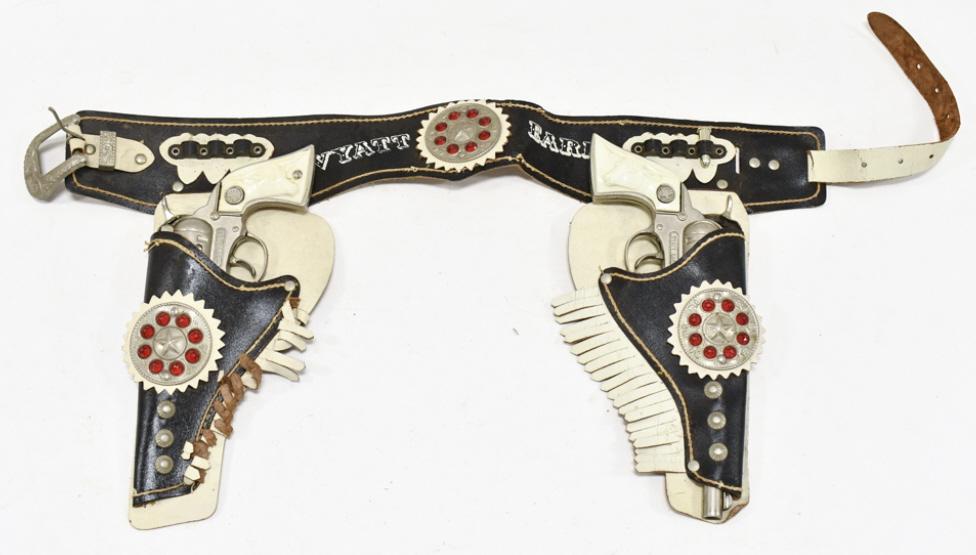 Long Island Wyatt Earp Cap Gun Set w/ Holster: Long Island Die Casting Inc. & Service Mfg. Wyatt Earp cap gun set with Wyatt Earp leather holster. The guns have corrosion and wear from use and age. Some of the grips are cracked / chipped. The hols