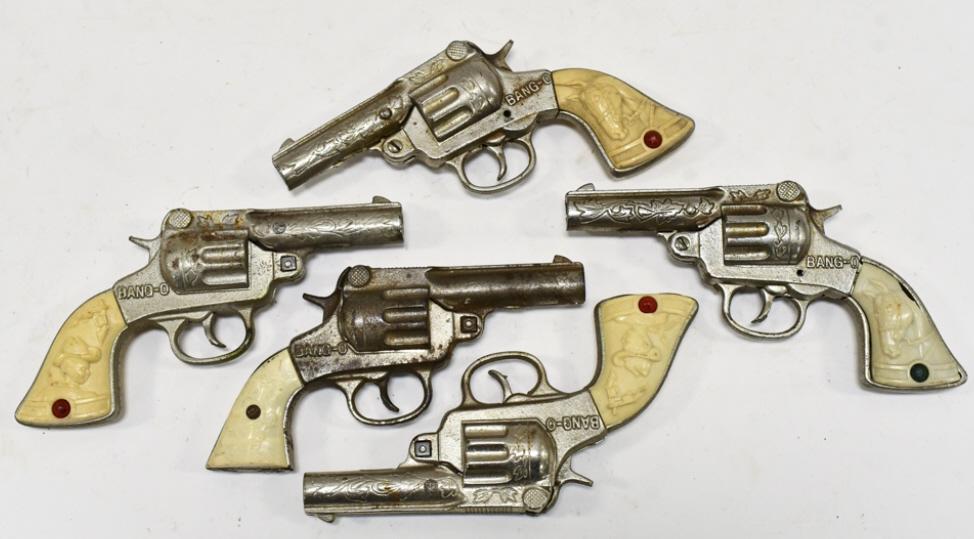 (5) Stevens Cast Iron Bang-O Cap Gun Pistols: (5) Stevens cast iron Bang-O cap gun pistols. Some of the guns have cracks or chips in the grips. All have wear from use and age. Each gun measures approximately 7" long.