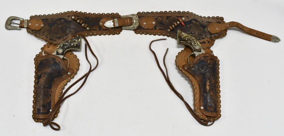 Hubley Texan Jr. Cap Gun Pistols w Leather Holster: Hubley Texan Jr. cap gun pistols with leather hoslter. The cap guns have some corrosion and wear from use and age. The holster has some cracking and wear from age. Each gun measures approximately 9-1/