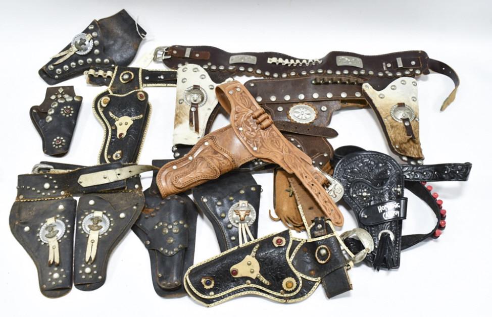Lot Of Vintage Leather Cap Gun Holsters: Lot of vintage leather cap gun holsters. Includes belts, some single holsters, and some dual holsters. Some with belts and some without. All have wear from use and age.