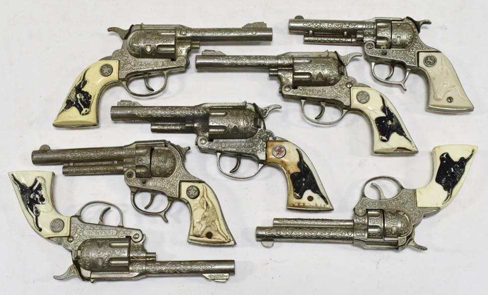 (7) Hubley Texan Jr. Cap Gun Pistols: (7) Hubley Texan Jr. cap gun pistols. The pistols vary in age and condition.. The one gun has a broken hammer. All have wear from use and age. Longest measures approximately 9-1/2" long.