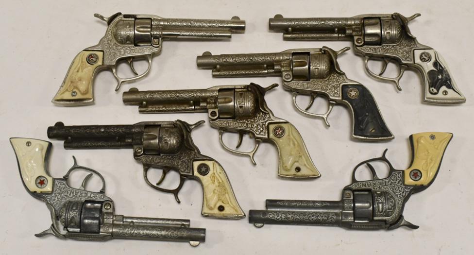 (7) Hubley Cast Iron Texan Cap Guns: (7) Hubley cast iron Texan cap guns. The guns have some corrosion and wear from use and age. Each gun measures approximately 9-1/2" long.